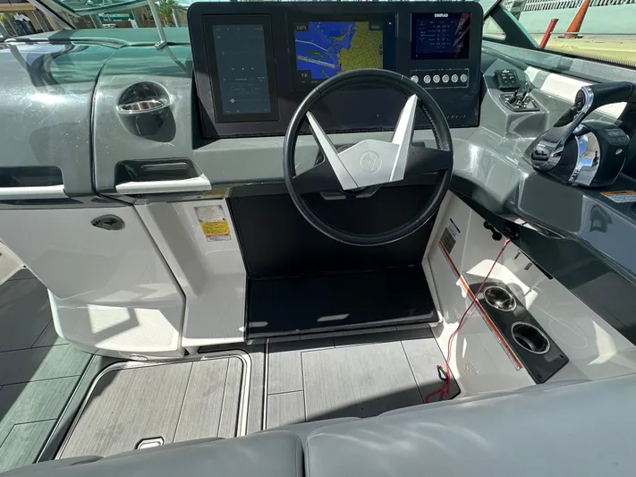  Yacht Photos Pics 2022 Aviara AV 32 OB boat dashboard with steering wheel and navigation screens.