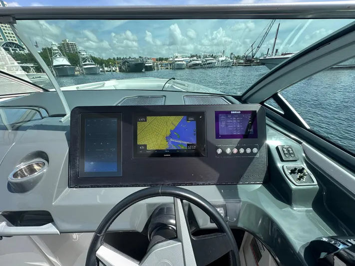  Yacht Photos Pics 2022 Aviara AV 32 OB dashboard with navigation screens, steering wheel, and marina view.