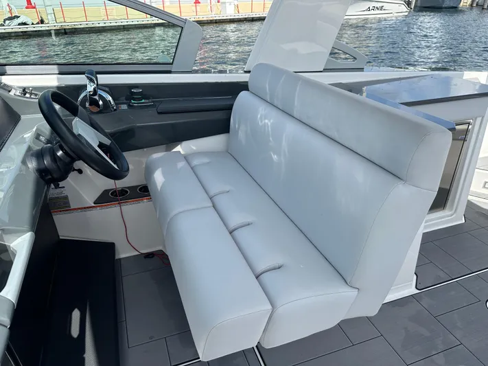  Yacht Photos Pics 2022 Aviara AV 32 OB boat interior with white seating and steering wheel, dockside view.