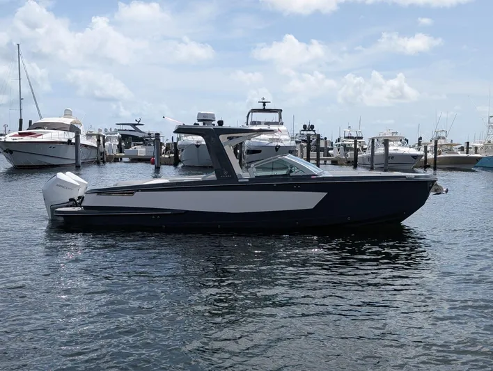  Yacht Photos Pics 2022 Aviara AV 32 OB boat docked in marina, surrounded by other vessels under a cloudy sky.