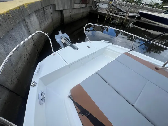  Yacht Photos Pics 2025 Beneteau Flyer 9 SUNdeck boat with cushioned seating and anchor, docked in marina.