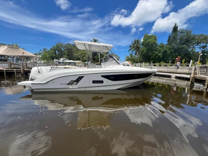  Yacht Photos Pics 2025 Beneteau Flyer 9 SUNdeck boat docked on calm water under blue sky.