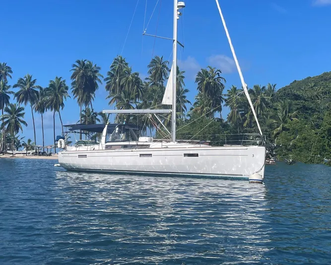 Drift Yacht Photos Pics 2015 Beneteau Oceanis 45 sailboat anchored near tropical palm trees.