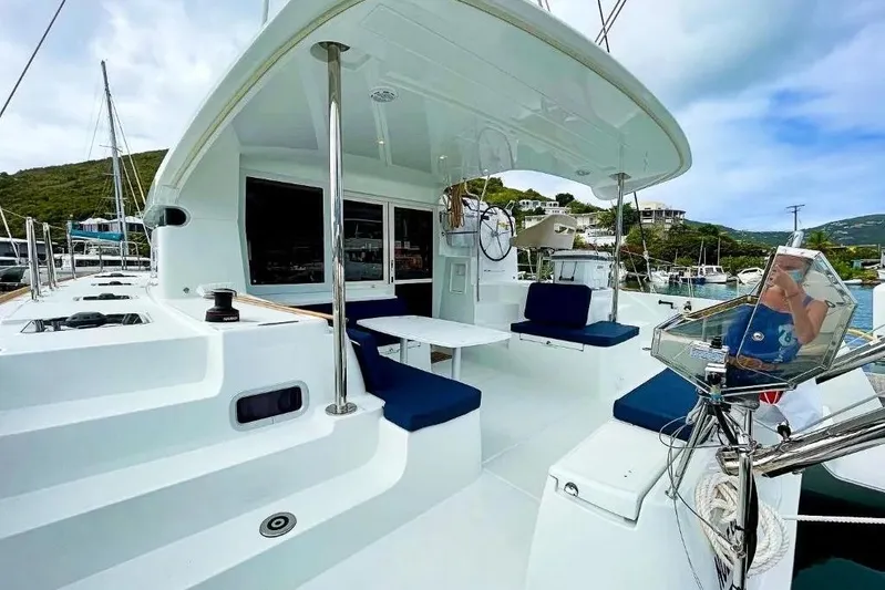 Noble Shadow Yacht Photos Pics 2022 Lagoon 40 catamaran with spacious deck and seating, docked in a scenic marina.