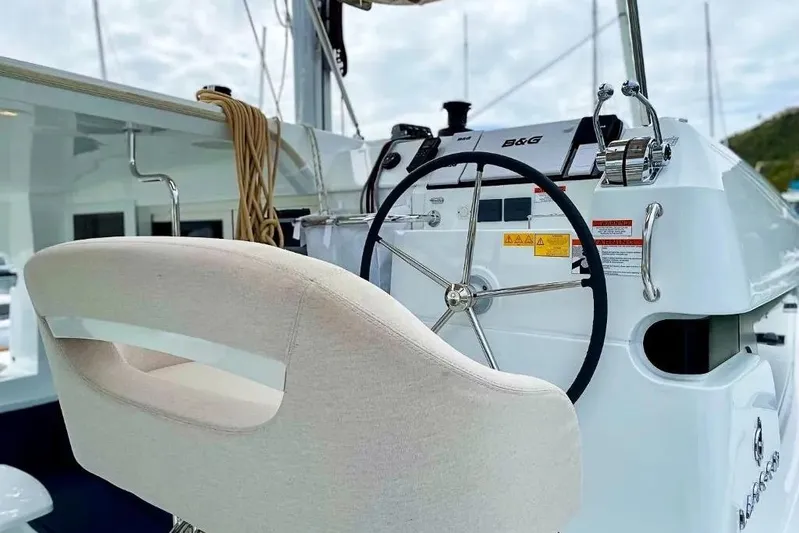 Noble Shadow Yacht Photos Pics Helm of 2022 Lagoon 40 catamaran with steering wheel and navigation controls.