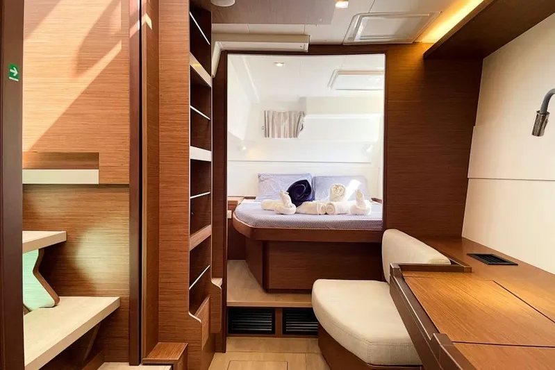 Noble Shadow Yacht Photos Pics Luxurious interior of 2022 Lagoon 40 catamaran with cozy bedroom and elegant wood finishes.
