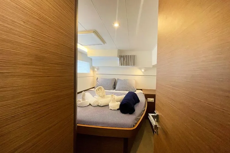 Noble Shadow Yacht Photos Pics Luxurious cabin interior of 2022 Lagoon 40 yacht with neatly arranged bed linens.