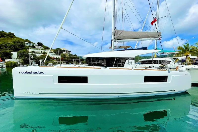 Noble Shadow Yacht Photos Pics 2022 Lagoon 40 catamaran docked in a tropical marina setting.