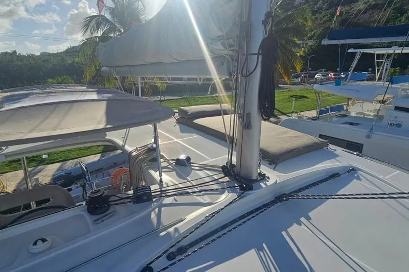 Noble Shadow Yacht Photos Pics 2022 Lagoon 40 catamaran deck with sunlit sails and tropical backdrop.