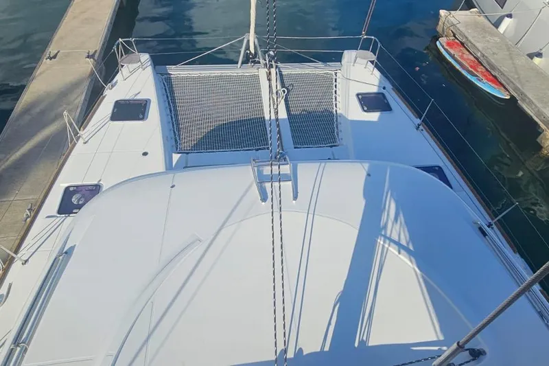 Noble Shadow Yacht Photos Pics 2022 Lagoon 40 catamaran docked, featuring spacious deck and netting area.