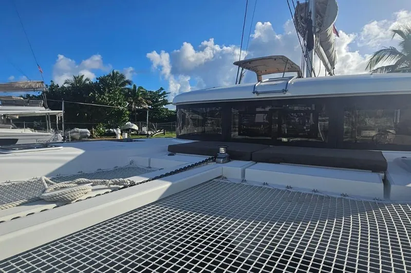 Noble Shadow Yacht Photos Pics 2022 Lagoon 40 catamaran with netted deck, moored under a clear blue sky.