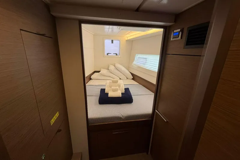 Noble Shadow Yacht Photos Pics Interior cabin of 2022 Lagoon 40 yacht with neatly arranged bed and towels.