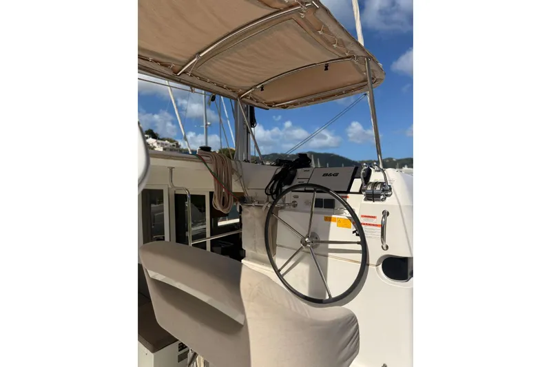Noble Shadow Yacht Photos Pics Helm of 2022 Lagoon 40 catamaran with steering wheel and navigation equipment.