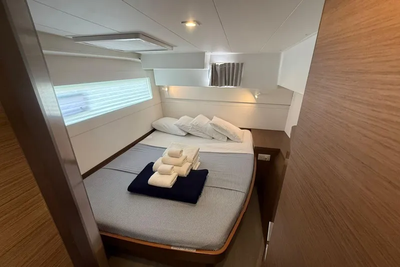 Noble Shadow Yacht Photos Pics Luxurious cabin interior of 2022 Lagoon 40 yacht with neatly arranged bed and towels.