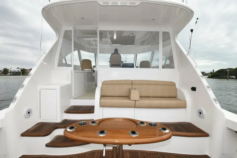 Galati Yacht Sales Trade Yacht Photos Pics 2022 Viking 44 Sport Coupe yacht with elegant seating and wooden table on deck.