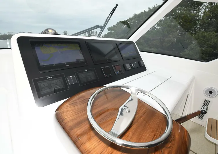 Galati Yacht Sales Trade Yacht Photos Pics 2022 Viking 44 Sport Coupe helm with modern navigation displays and sleek wooden steering wheel.