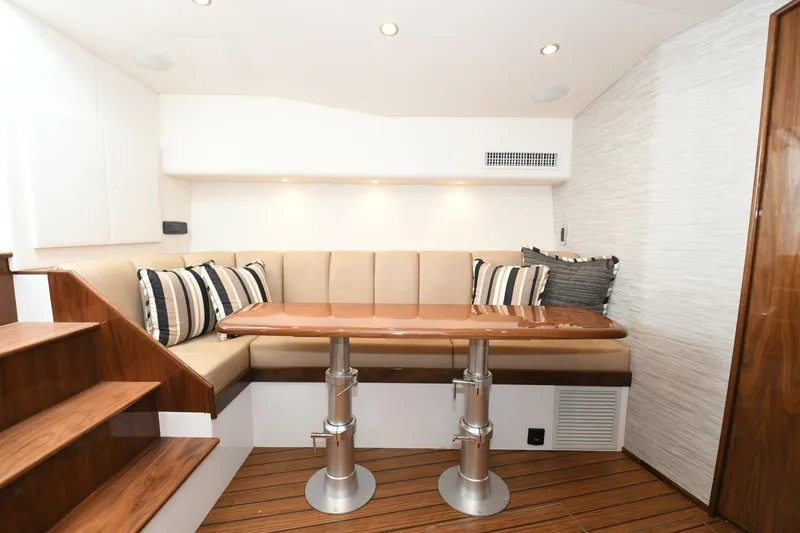 Galati Yacht Sales Trade Yacht Photos Pics Interior of 2022 Viking 44 Sport Coupe with elegant seating and wooden table.