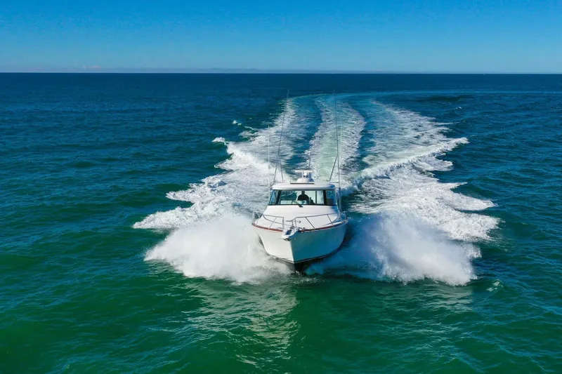 Galati Yacht Sales Trade Yacht Photos Pics 2022 Viking 44 Sport Coupe cruising on open ocean, leaving a wake behind.