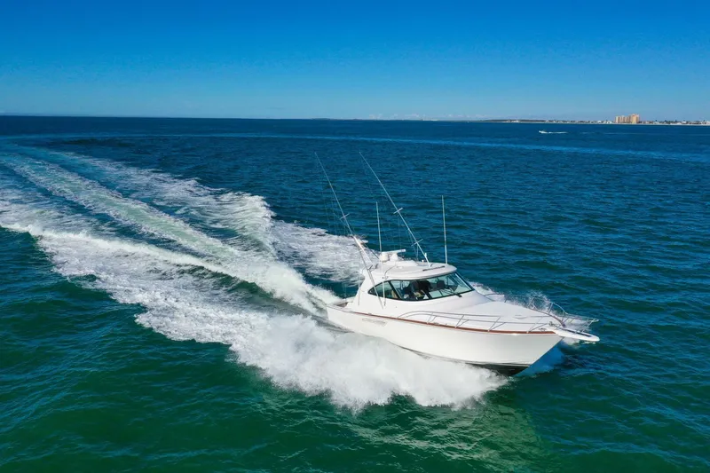 Galati Yacht Sales Trade Yacht Photos Pics 2022 Viking 44 Sport Coupe cruising on open water under clear blue skies.