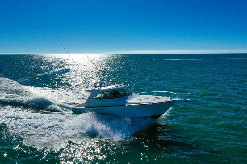Galati Yacht Sales Trade Yacht Photos Pics 2022 Viking 44 Sport Coupe cruising on open sea under clear blue sky.
