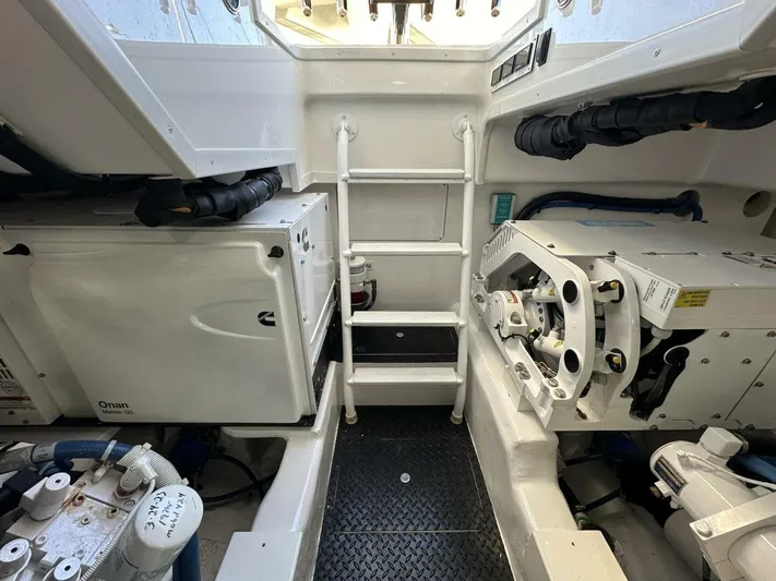 Galati Yacht Sales Trade Yacht Photos Pics Engine room of 2022 Viking 44 Sport Coupe, featuring equipment and ladder access.