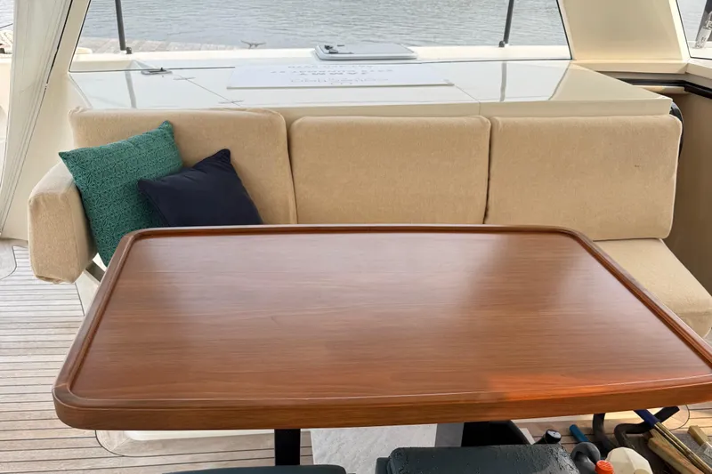 Jammy Yacht Photos Pics Luxurious seating area on a 2015 Gunboat 57' yacht with wooden table and cushions.