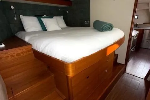 Jammy Yacht Photos Pics Luxurious bedroom interior of 2015 Gunboat 57' yacht with wooden furnishings and cozy bedding.