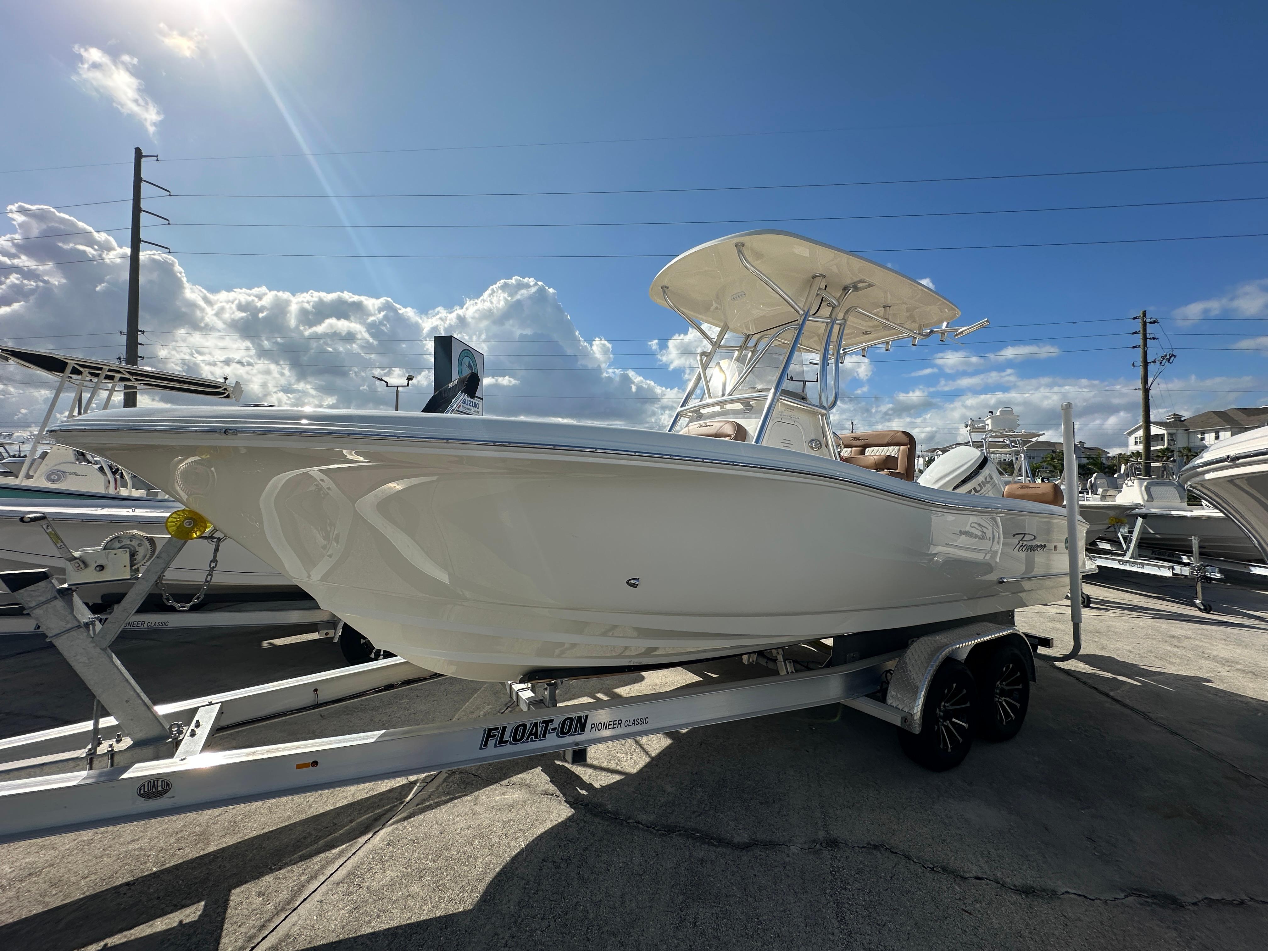 2025 Pioneer 222 Sportfish boat on trailer under sunny sky.