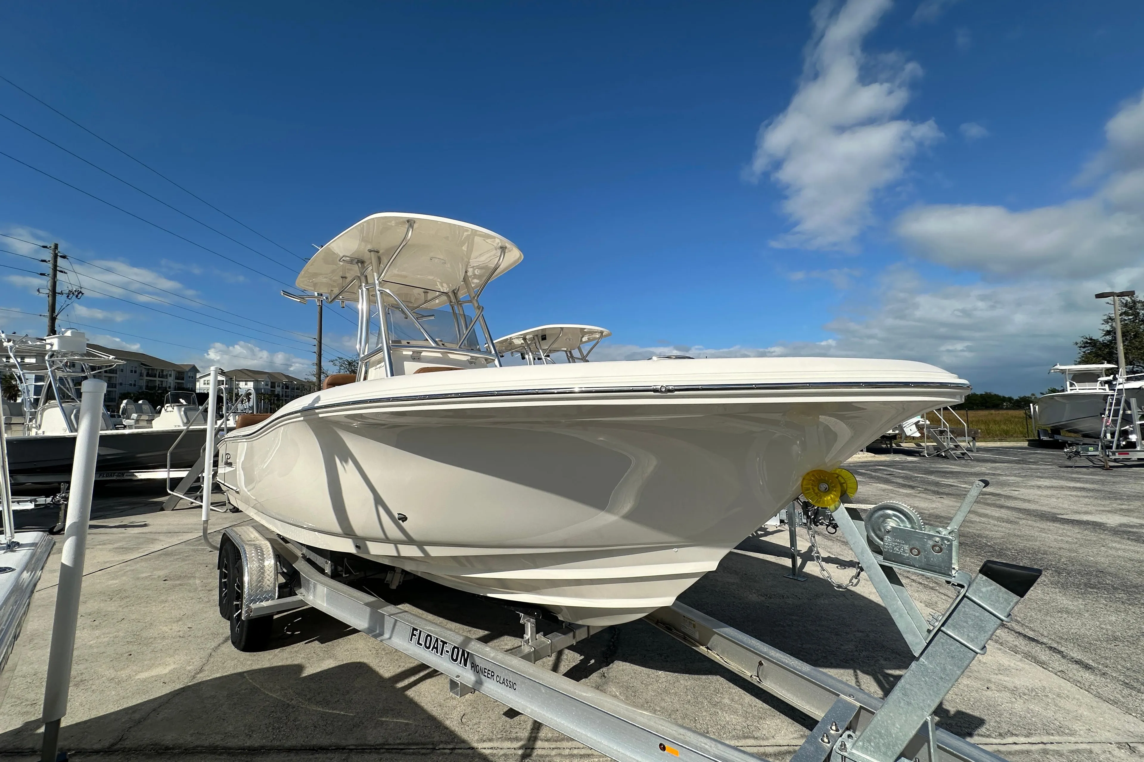 2025 Pioneer 222 Sportfish boat on trailer under clear blue sky.