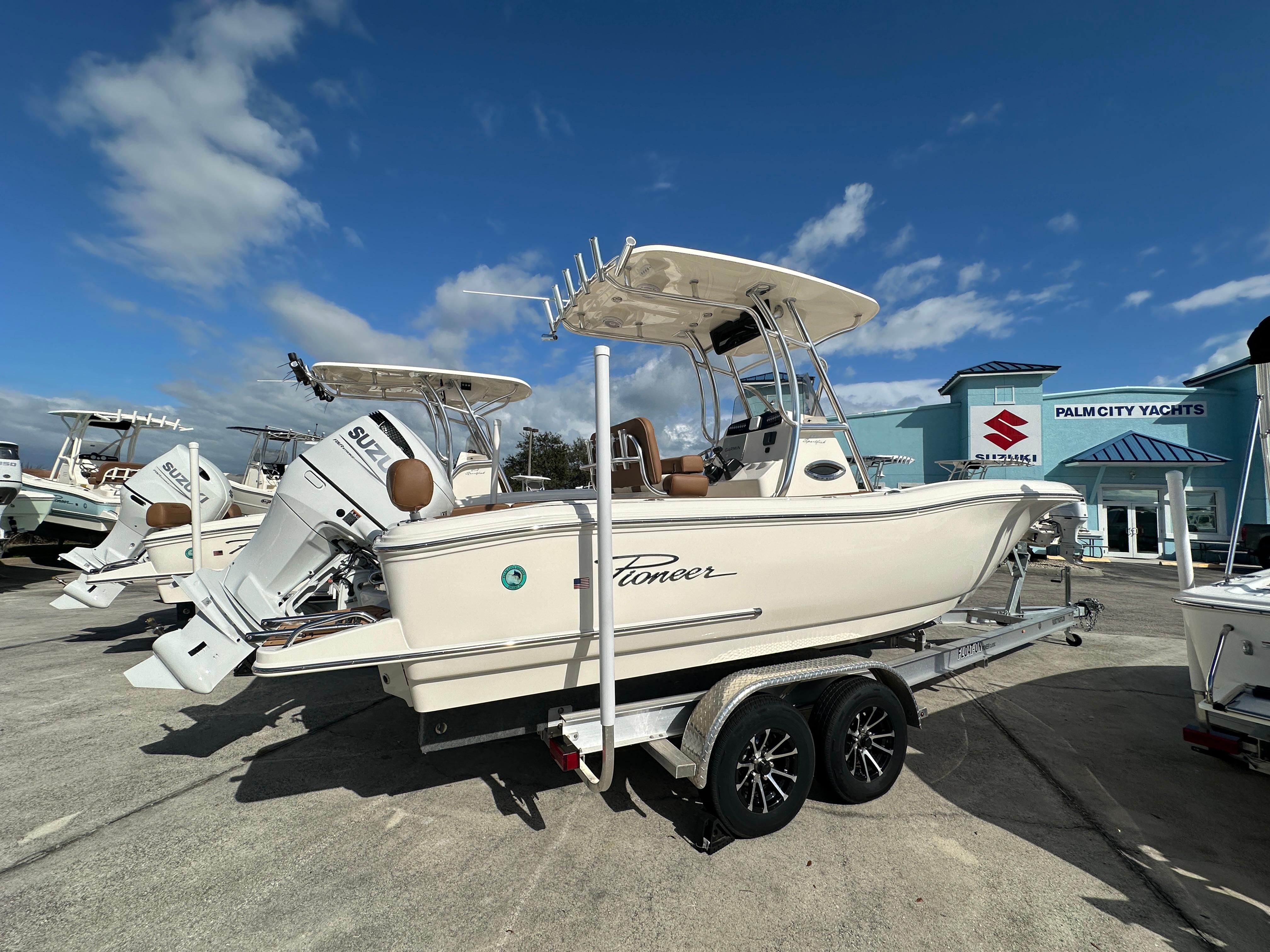 2025 Pioneer 222 Sportfish boat on trailer at Palm City Yachts dealership.