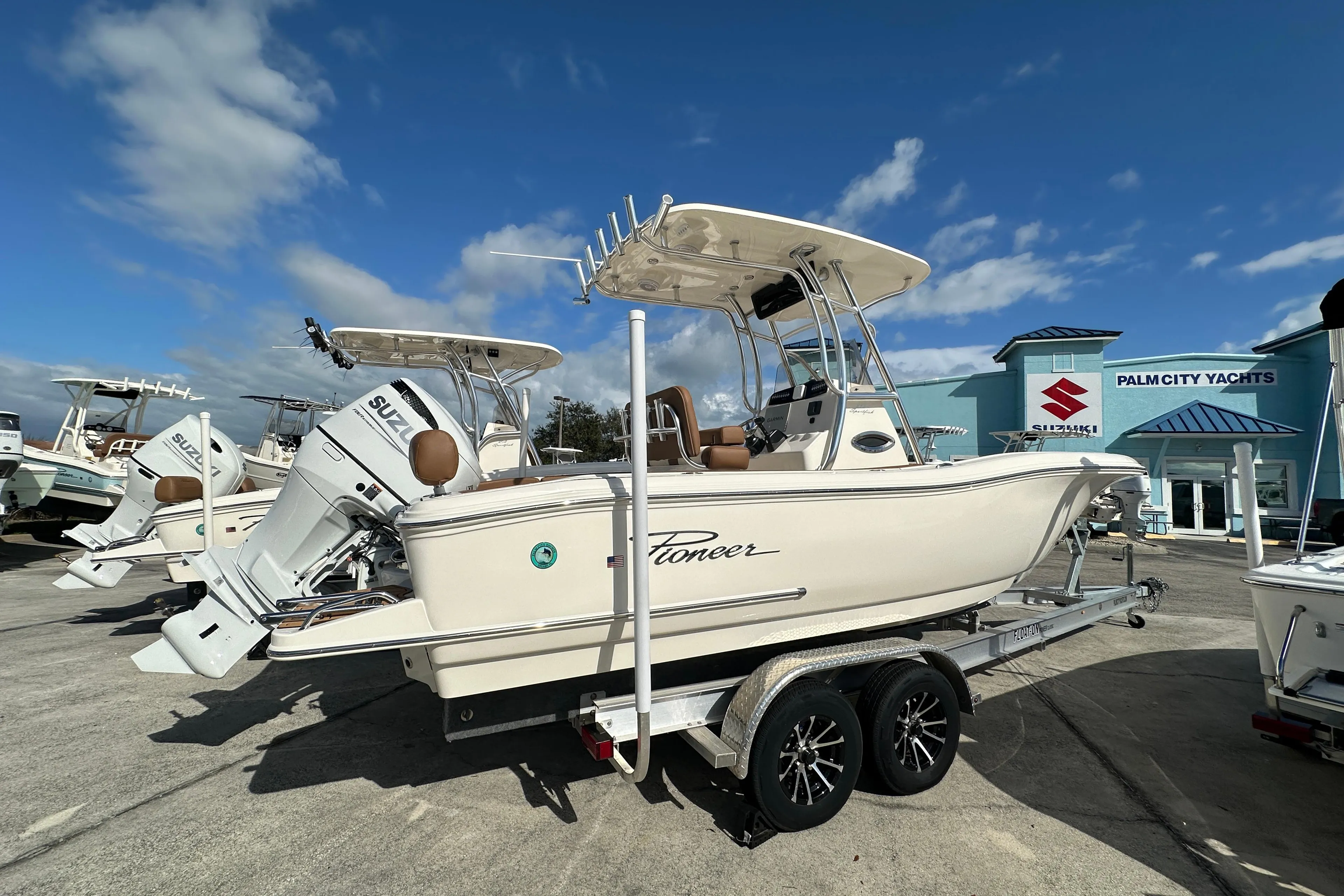 2025 Pioneer 222 Sportfish boat on trailer at Palm City Yachts dealership.