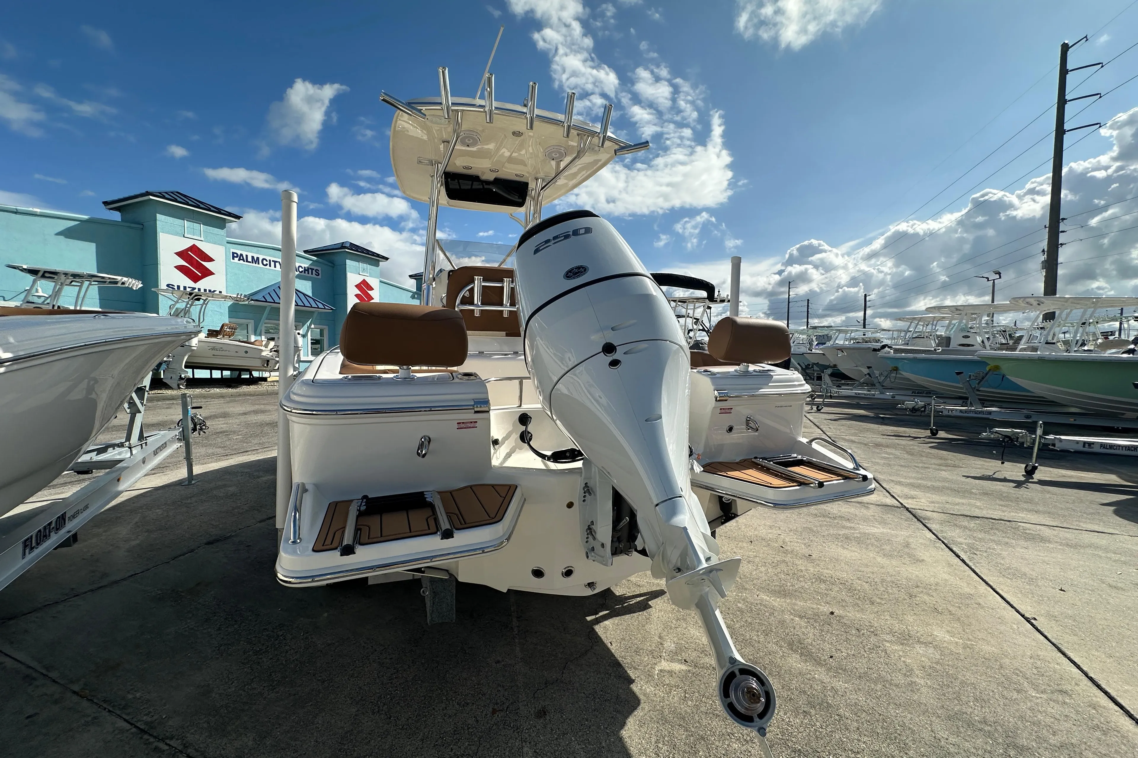 2025 Pioneer 222 Sportfish boat with outboard motor, docked under a partly cloudy sky.
