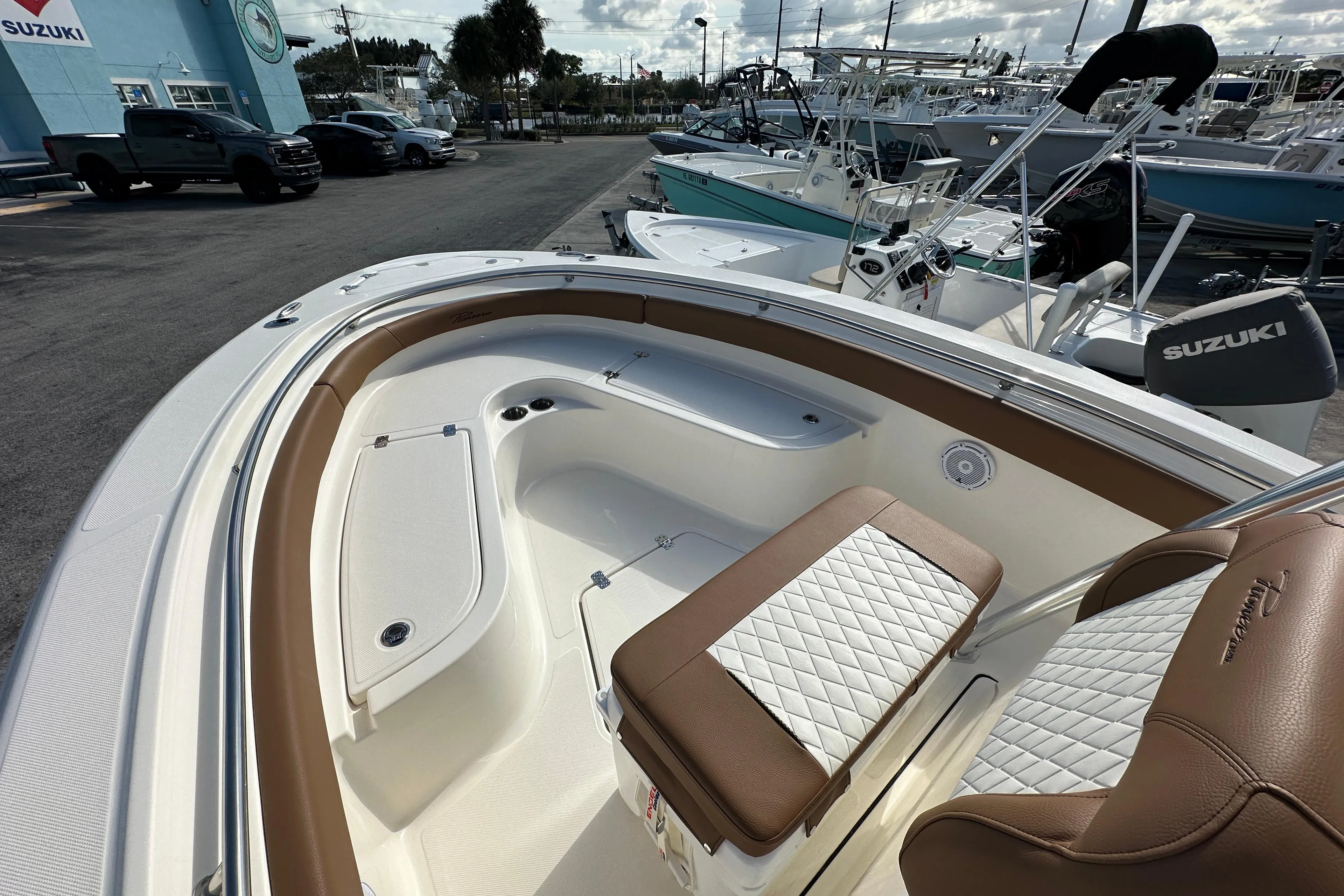2025 Pioneer 222 Sportfish boat interior with brown and white seating, docked at a marina.