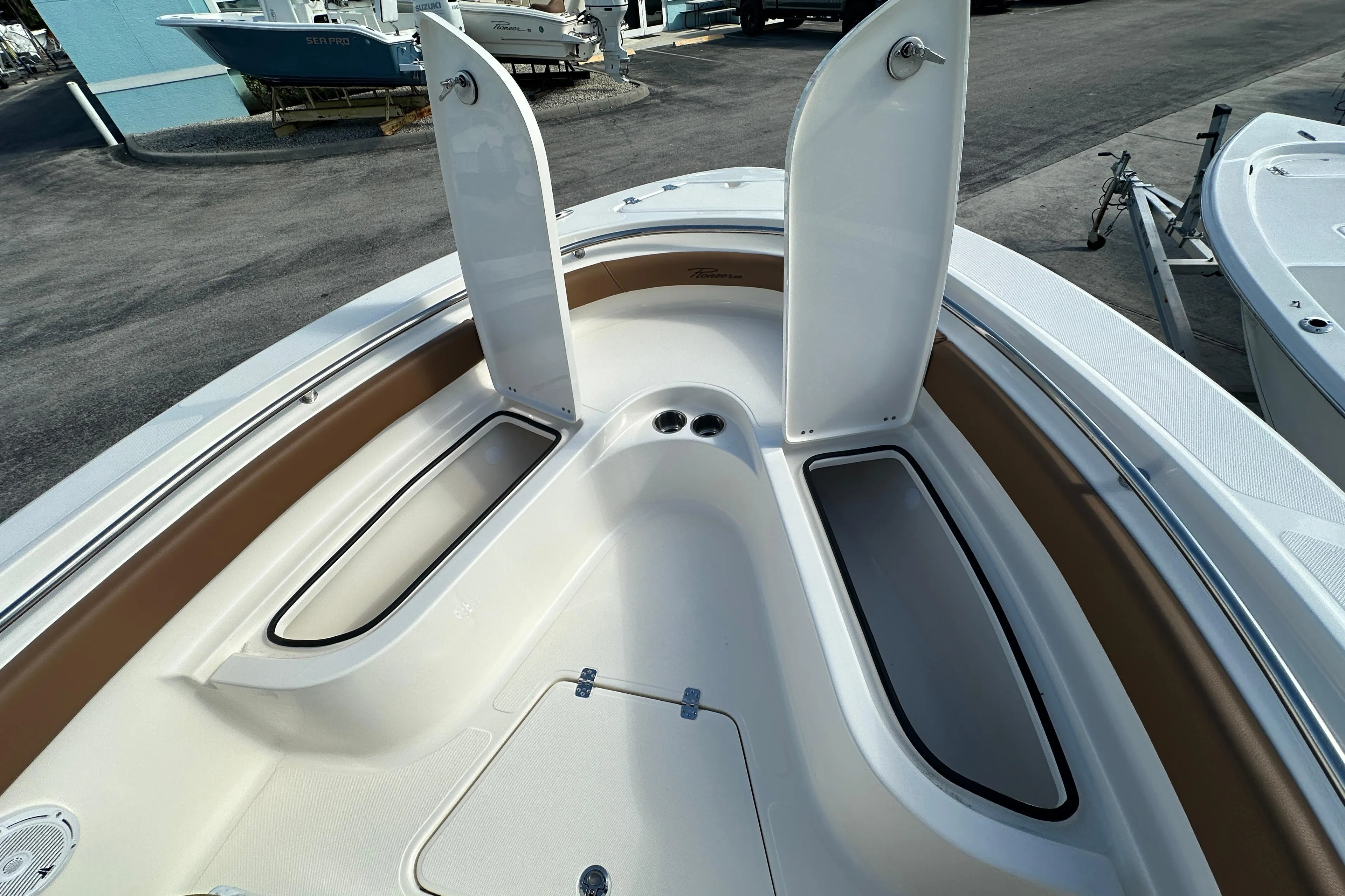 2025 Pioneer 222 Sportfish boat with open storage compartments on deck.
