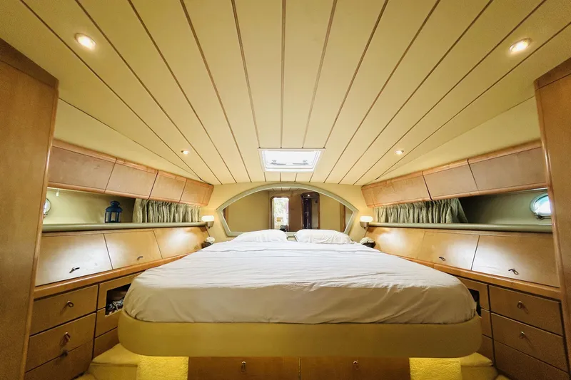 Yacht Photos Pics Luxurious 1992 Ferretti Yachts 45 Altura cabin with elegant wood finish and cozy bedding.
