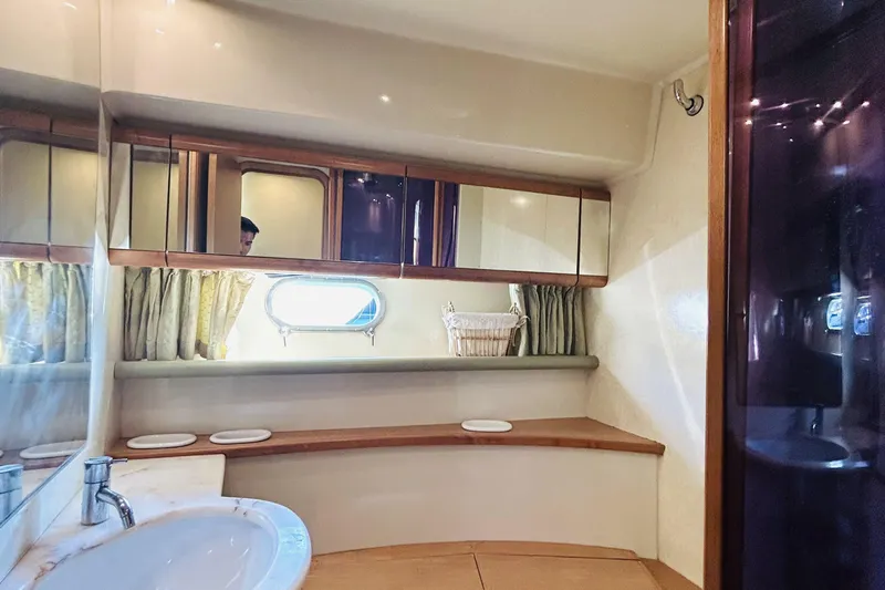  Yacht Photos Pics Luxurious bathroom interior of 1992 Ferretti Yachts 45 Altura with elegant wood accents.