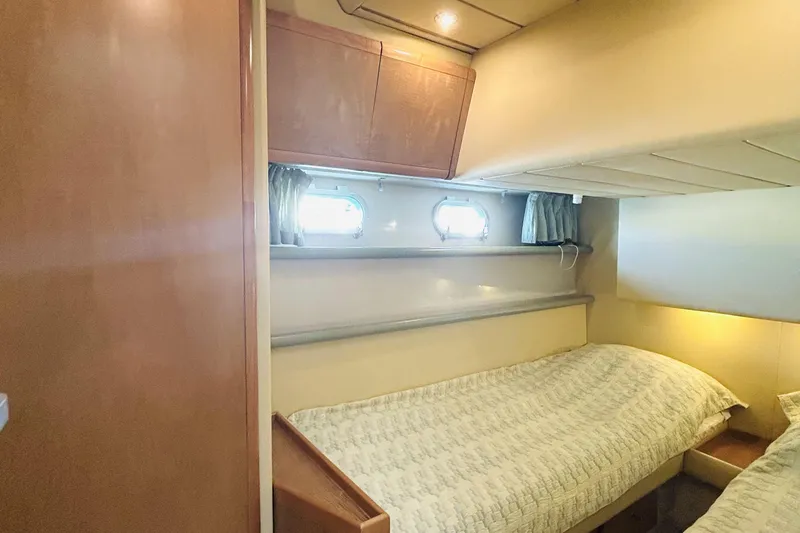  Yacht Photos Pics Cozy cabin interior of 1992 Ferretti Yachts 45 Altura with twin beds and porthole windows.