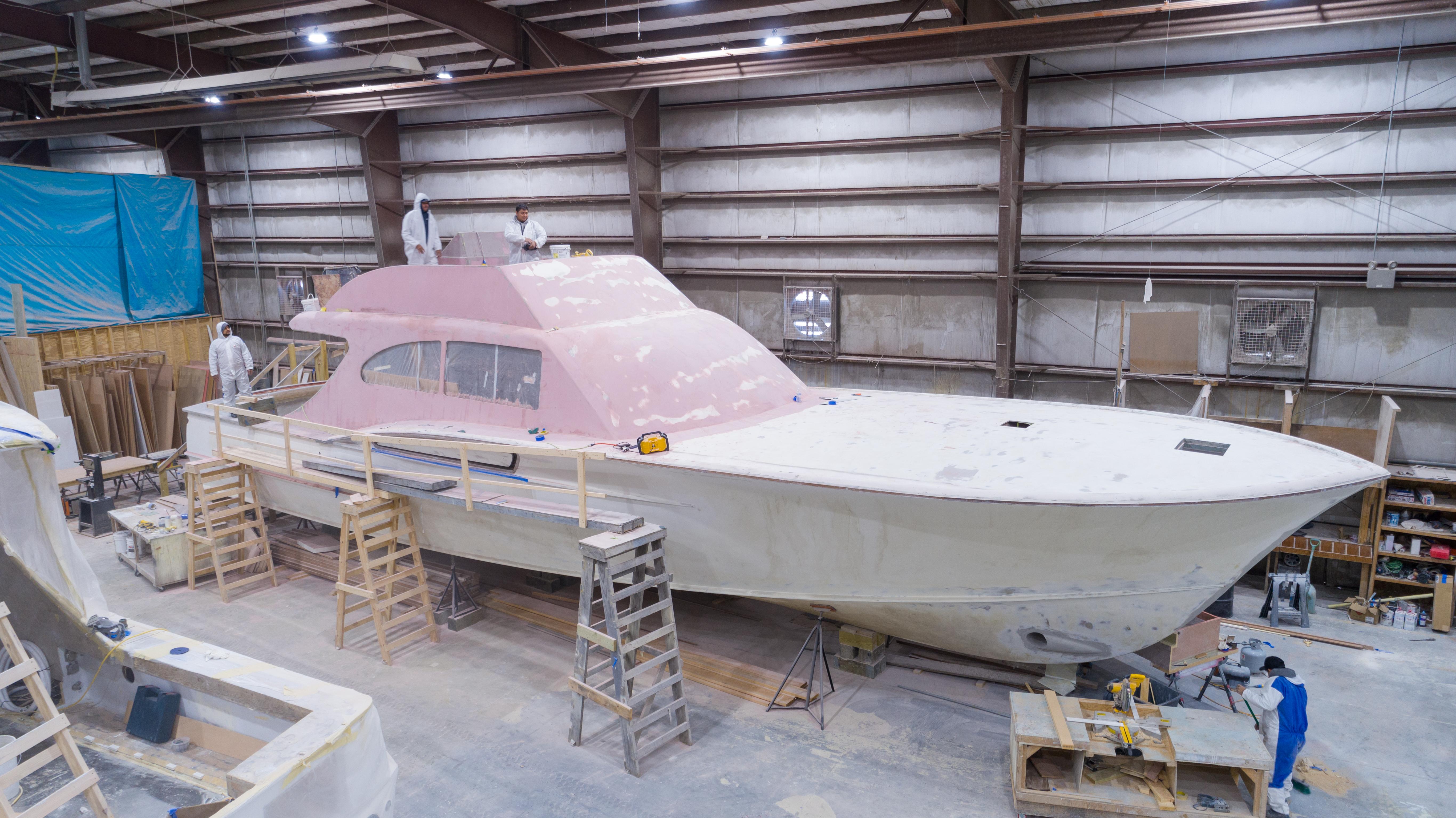 2024 Custom Carolina 63 yacht under construction in a workshop, showcasing skilled craftsmanship.