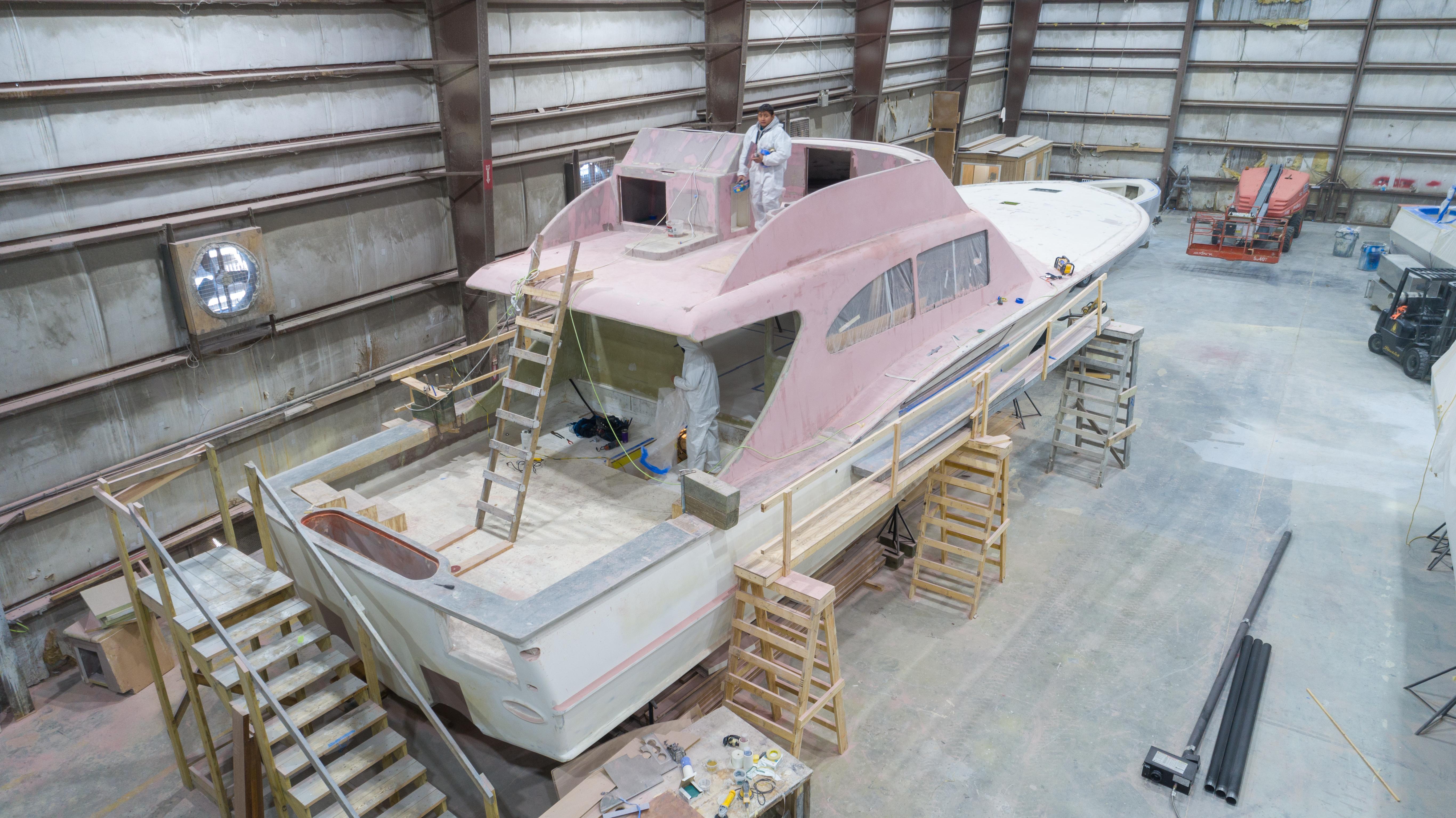 2024 Custom Carolina 63 yacht under construction in a large indoor facility.