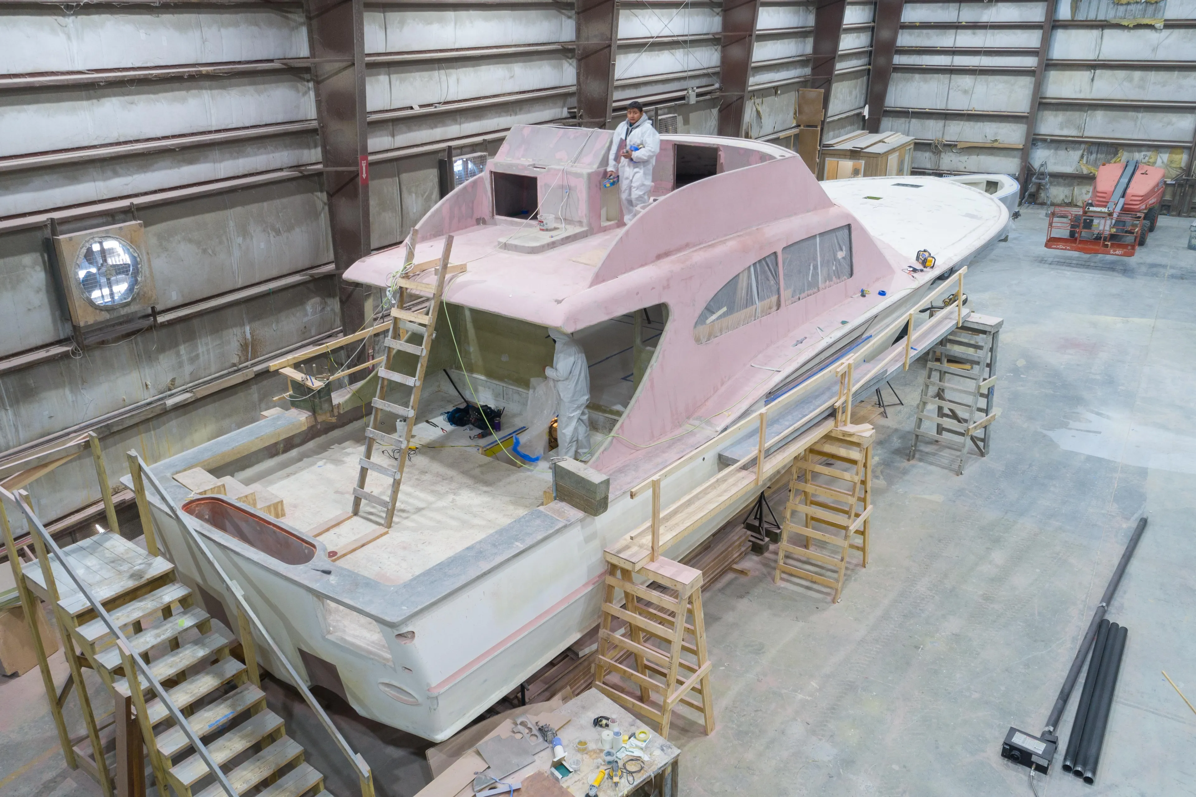 2024 Custom Carolina 63 yacht under construction in a large indoor facility.
