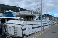 1970 Custom Bootswerft Burmester 24 yacht docked at marina, overcast sky.