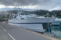 Vintage 1970 Custom Bootswerft Burmester 24 yacht docked by a scenic waterfront.