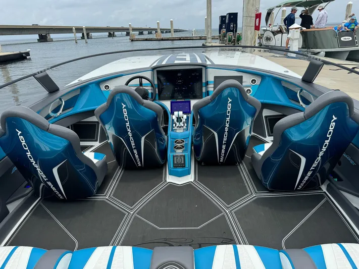  Yacht Photos Pics 2024 MTI 440X boat interior with blue seats and advanced dashboard at a marina.