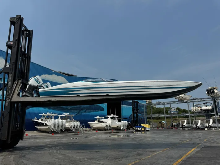  Yacht Photos Pics 2024 MTI 440X powerboat lifted by forklift in marina setting.