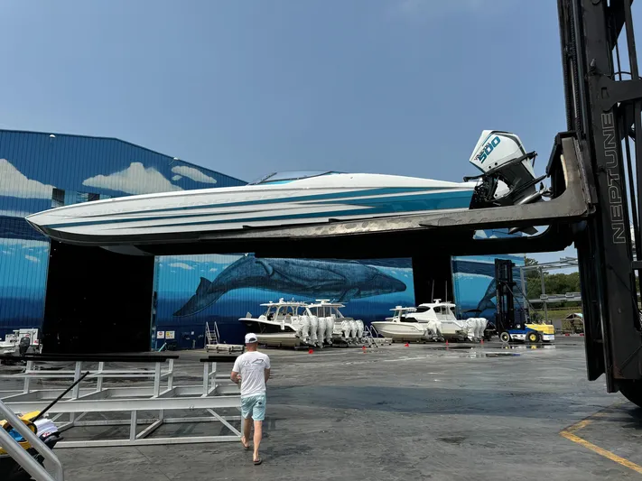  Yacht Photos Pics 2024 MTI 440X boat lifted by forklift in marina with whale mural background.