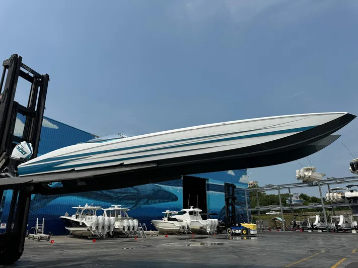  Yacht Photos Pics 2024 MTI 440X boat lifted by forklift in marina setting.