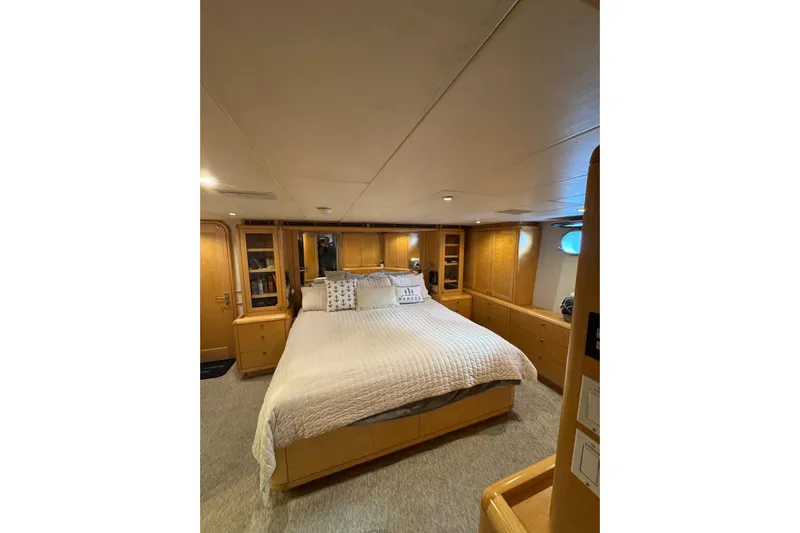 Evening Star Yacht Photos Pics Luxurious bedroom interior of 2003 Cape Horn Trawler with cozy bed and wooden cabinetry.