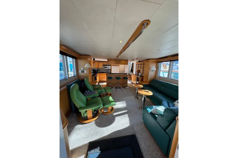 Evening Star Yacht Photos Pics Luxurious interior of 2003 Cape Horn Trawler with green seating and modern kitchen.