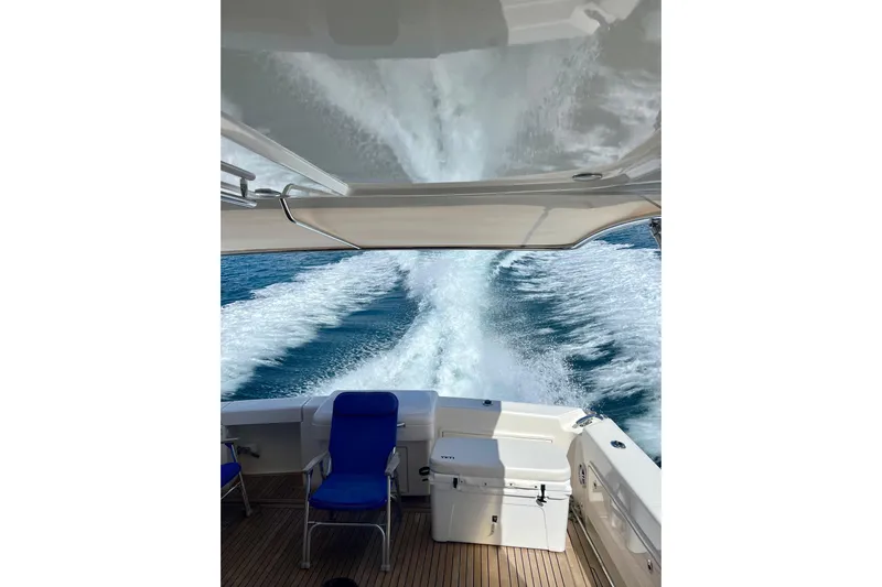  Yacht Photos Pics 2017 Riviera 445 SUV cruising, leaving a wake in the ocean, with blue seating on deck.