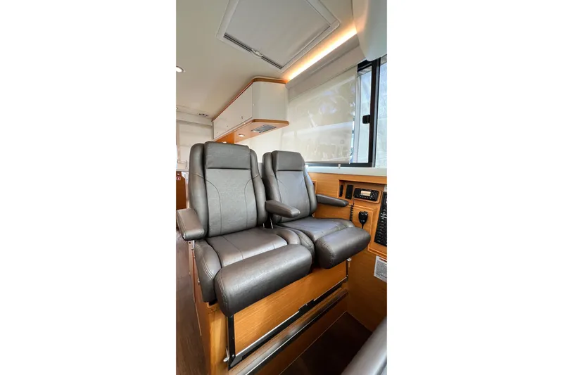  Yacht Photos Pics Luxurious interior seating of 2017 Riviera 445 SUV with leather chairs and wood accents.